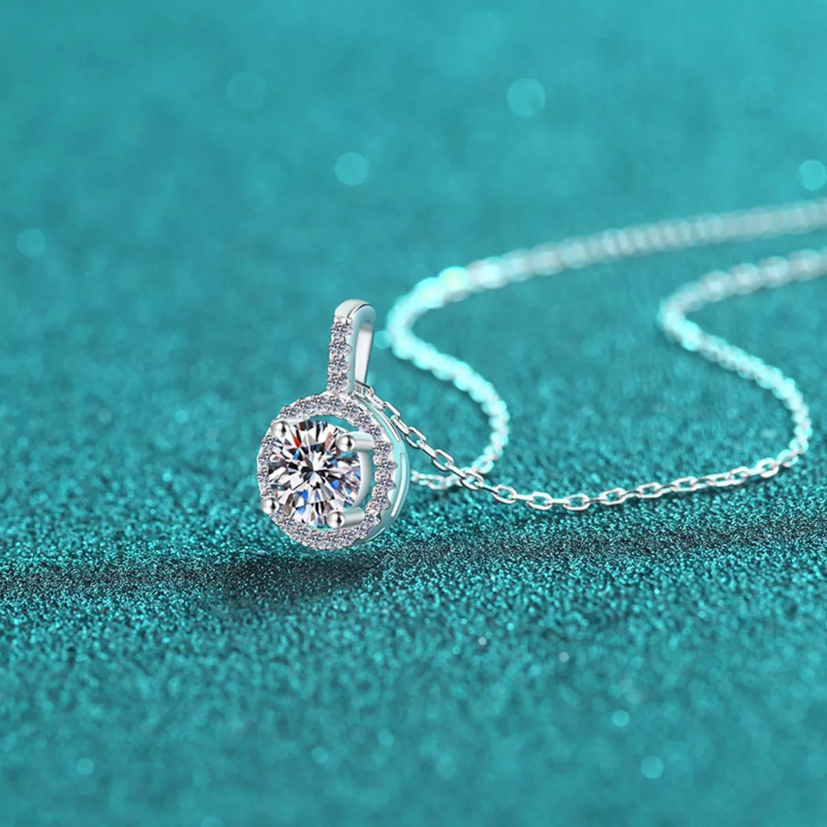 Silver necklace with a diamond pendant on a teal background