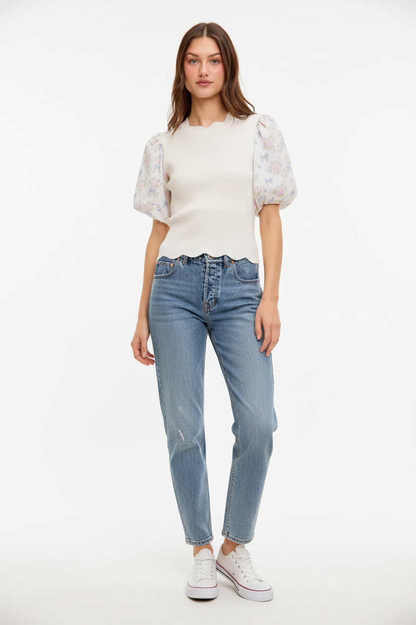 Cream knit top with sheer floral puff sleeves and scalloped hem, styled with blue jeans