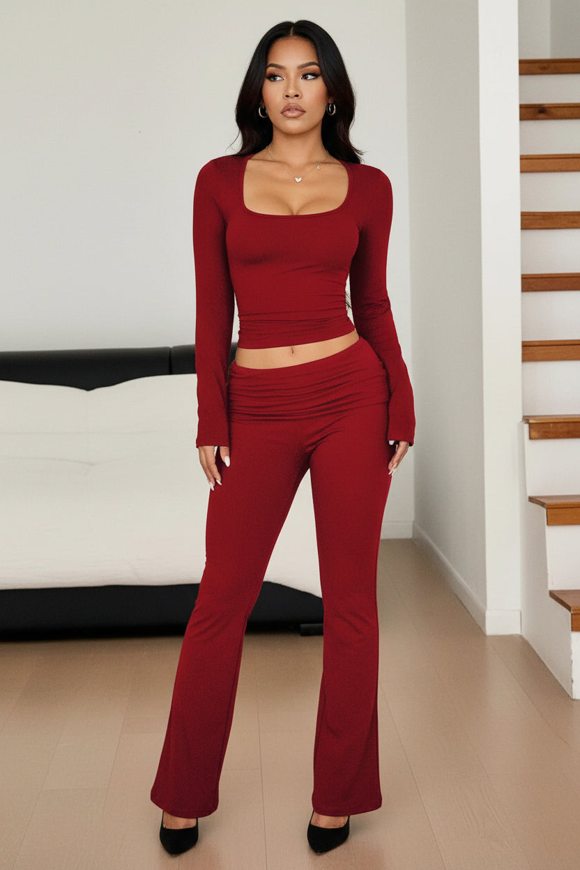 Person wearing a red long-sleeve top and leggings set indoors.