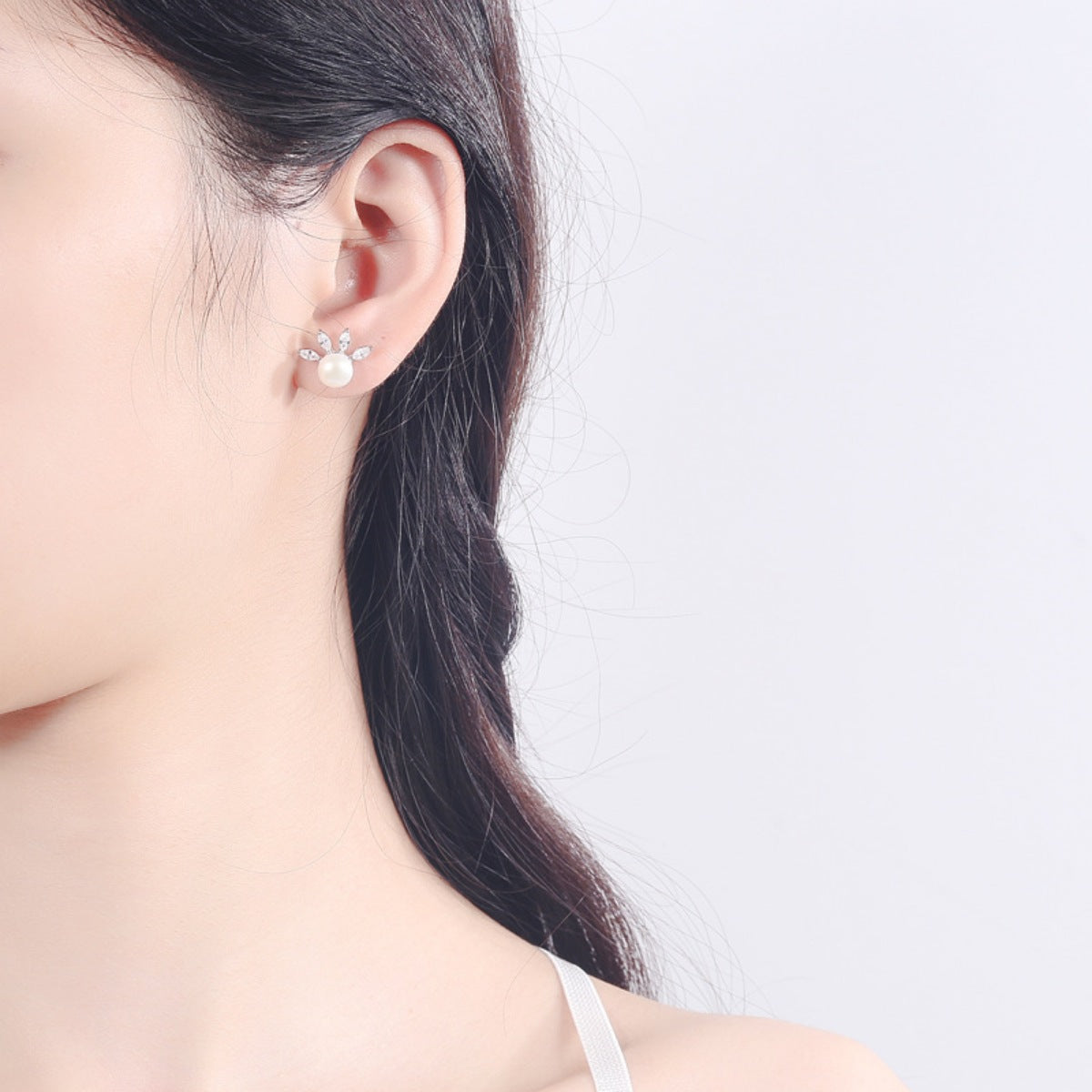 Rebellious woman wearing minimalist pearl stud earrings lifestyle close-up