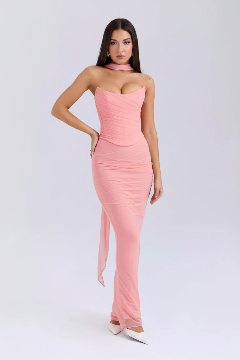 Pink strapless gown with a slit on a white background