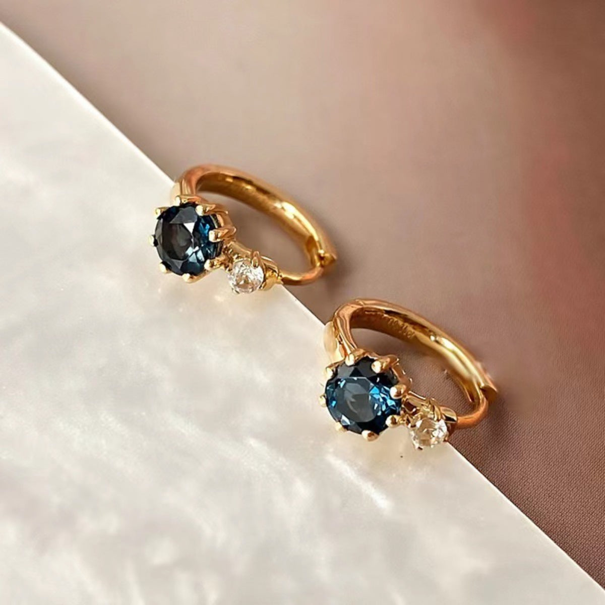 Detail shot of 18K gold-plated hoops with zircon accents and sterling silver base
