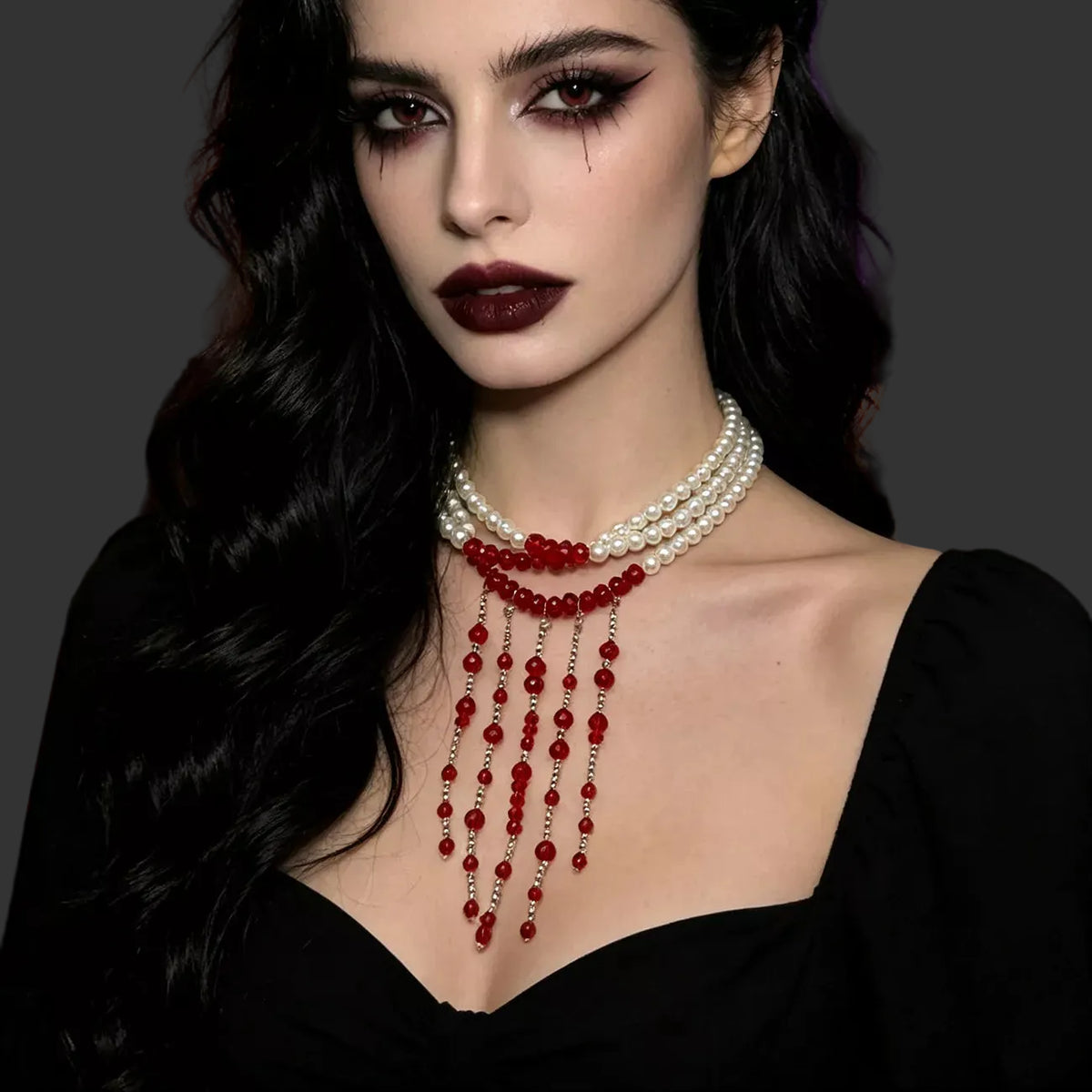 White pearl choker with red beaded fringe worn with a black top