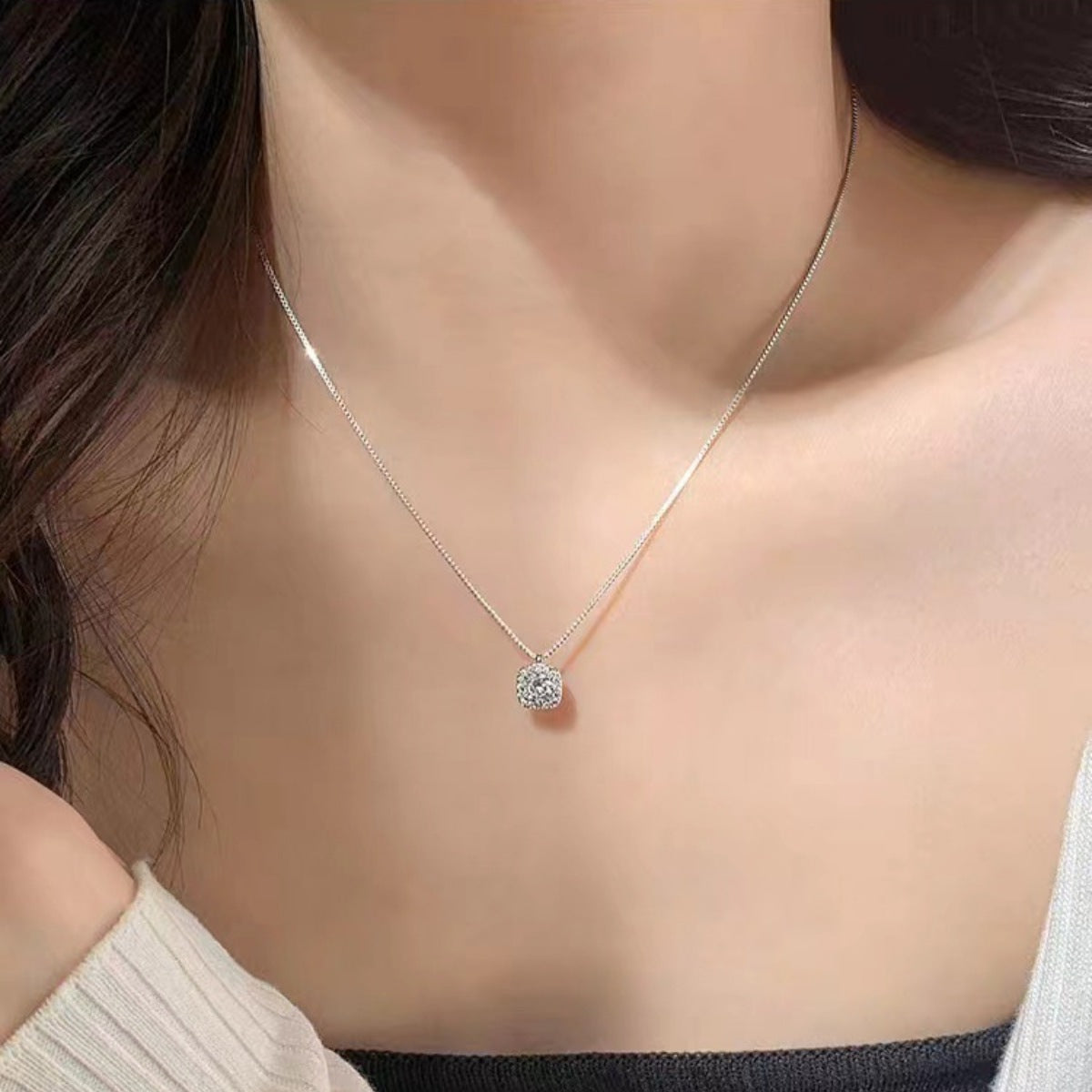 Model layering the square zircon necklace with other bold chains