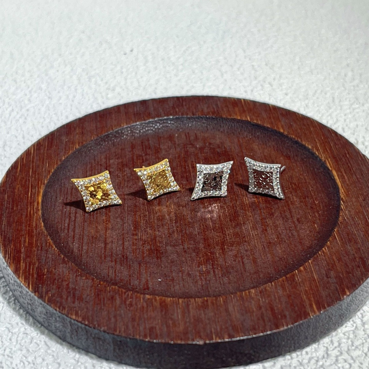 Close-up of bold geometric shape on 18K gold-plated stud earrings