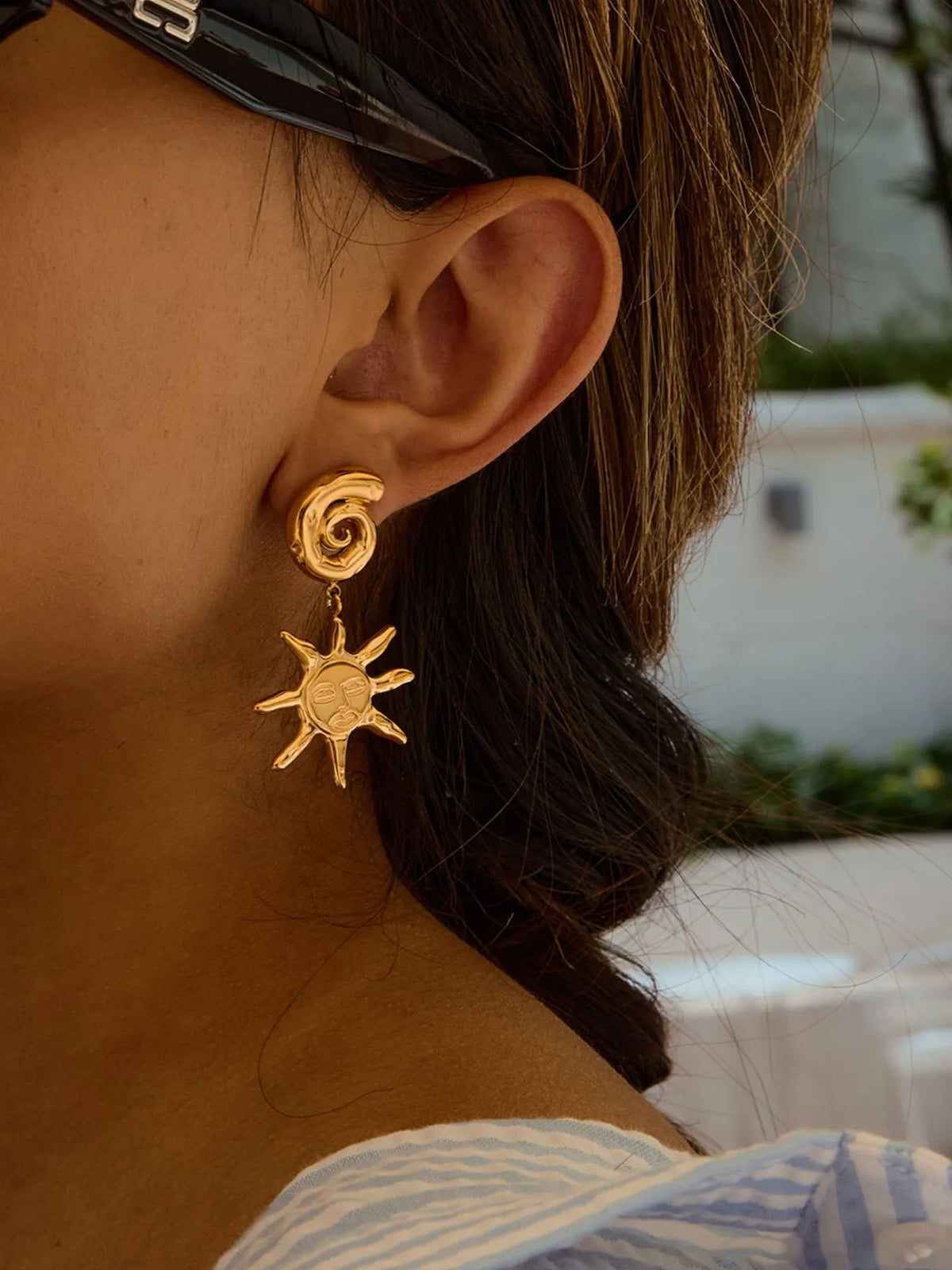 sun moon earrings on a model wearing sun glasses
