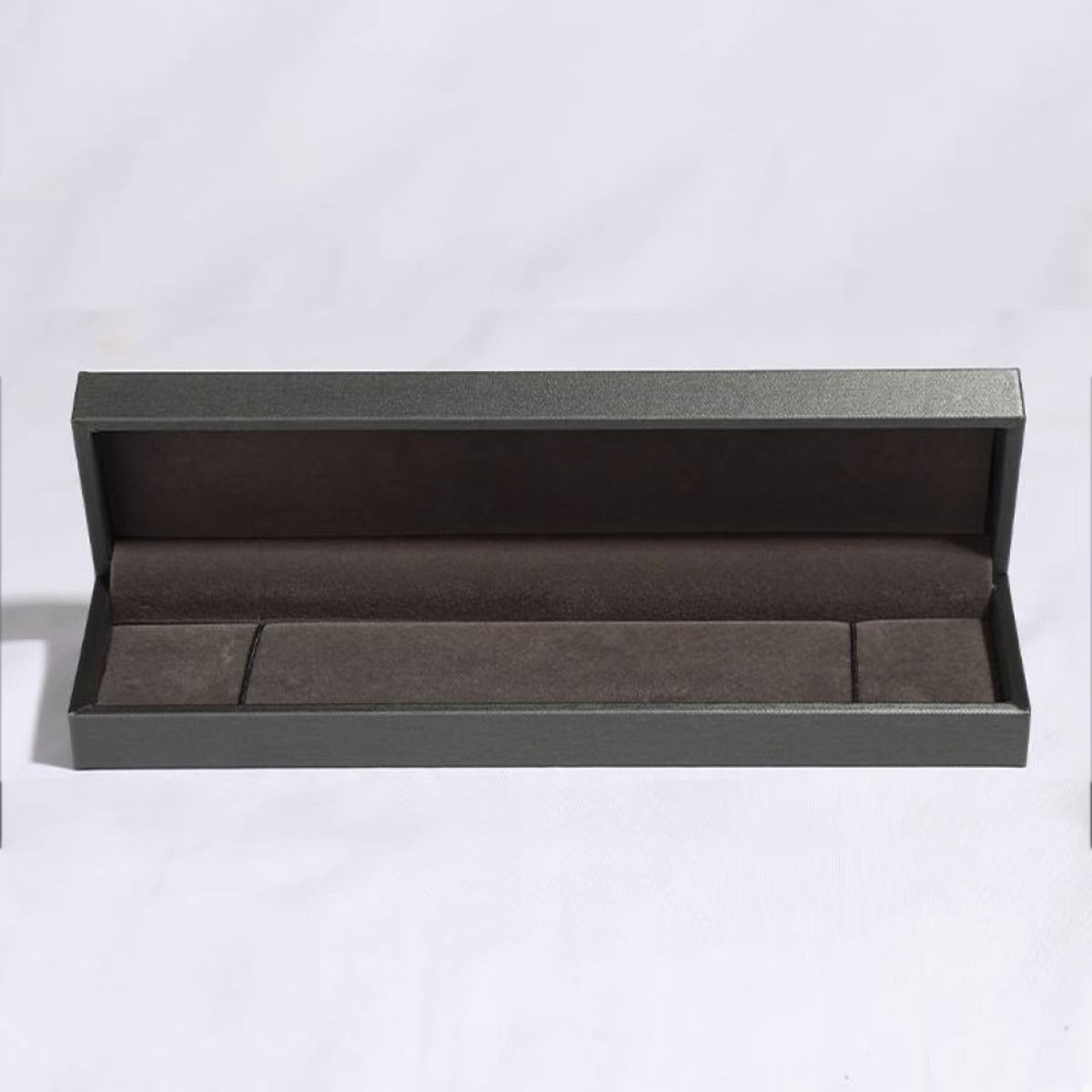 Product shot of four-leaf clover bracelet arranged neatly with matching box