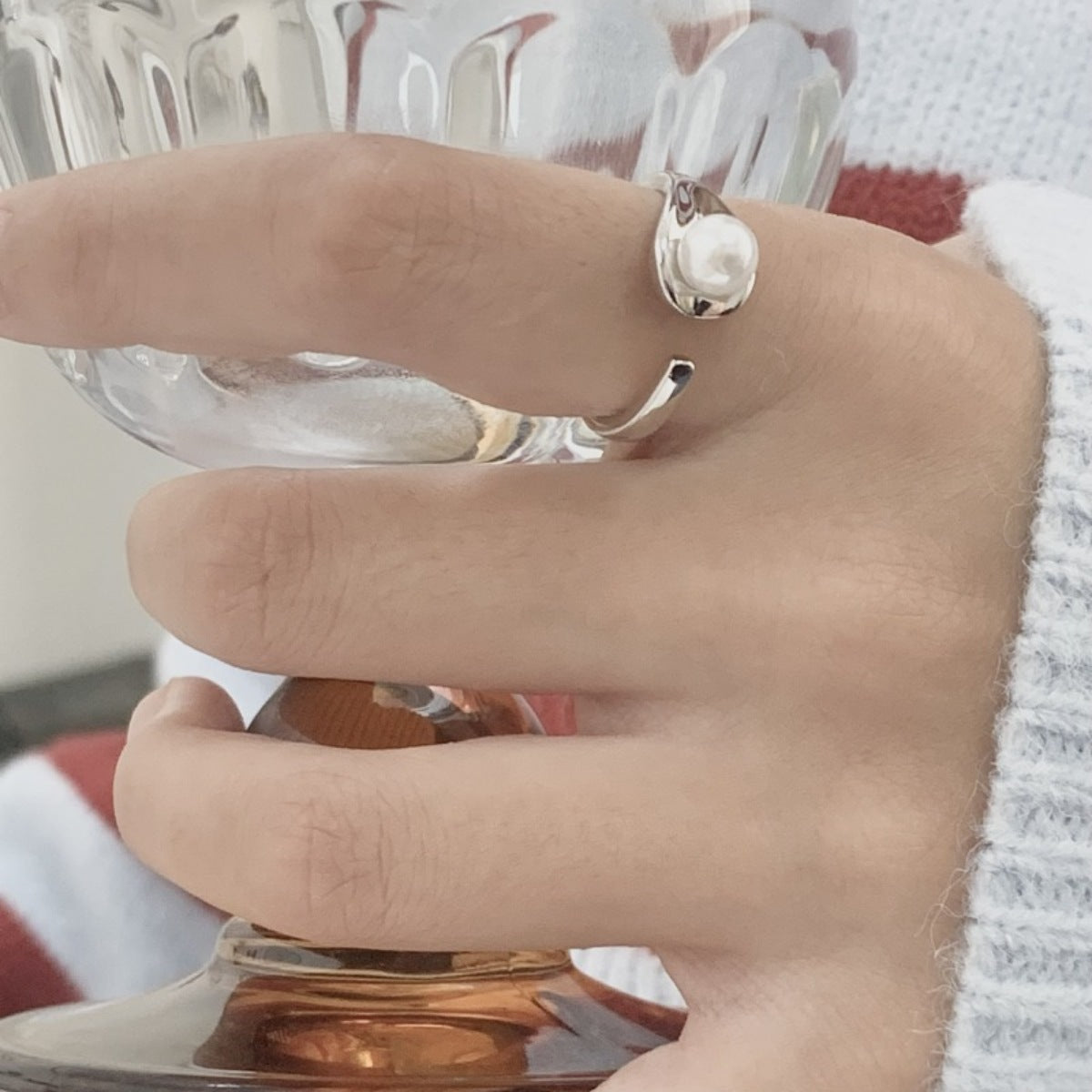 Model stacking the pearl cuff ring with other silver rings for bold hand styling