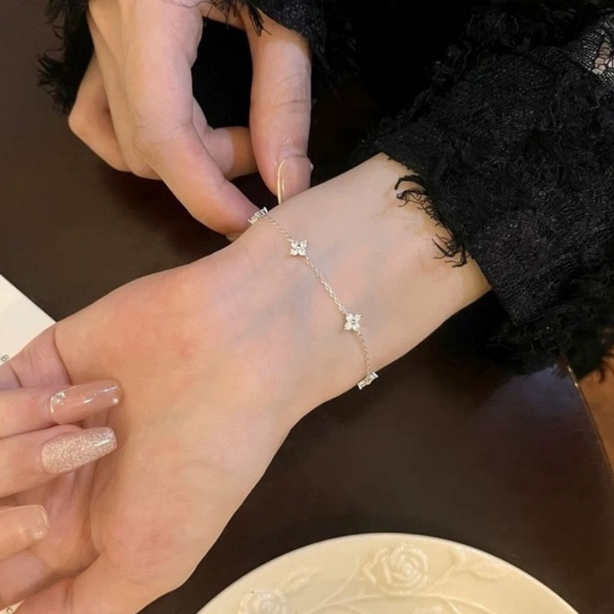 Close-up of sparkling four-leaf clover charm with zircon stones on gold-plated chain