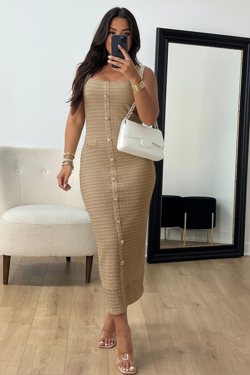 Woman taking a mirror selfie wearing a beige button-up dress in a room.