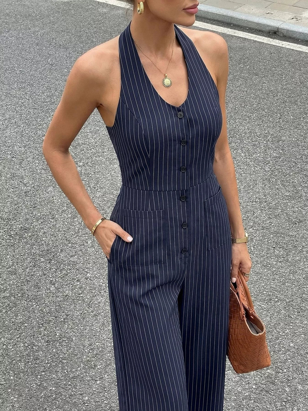 Woman wearing a navy pinstripe jumpsuit on a street.