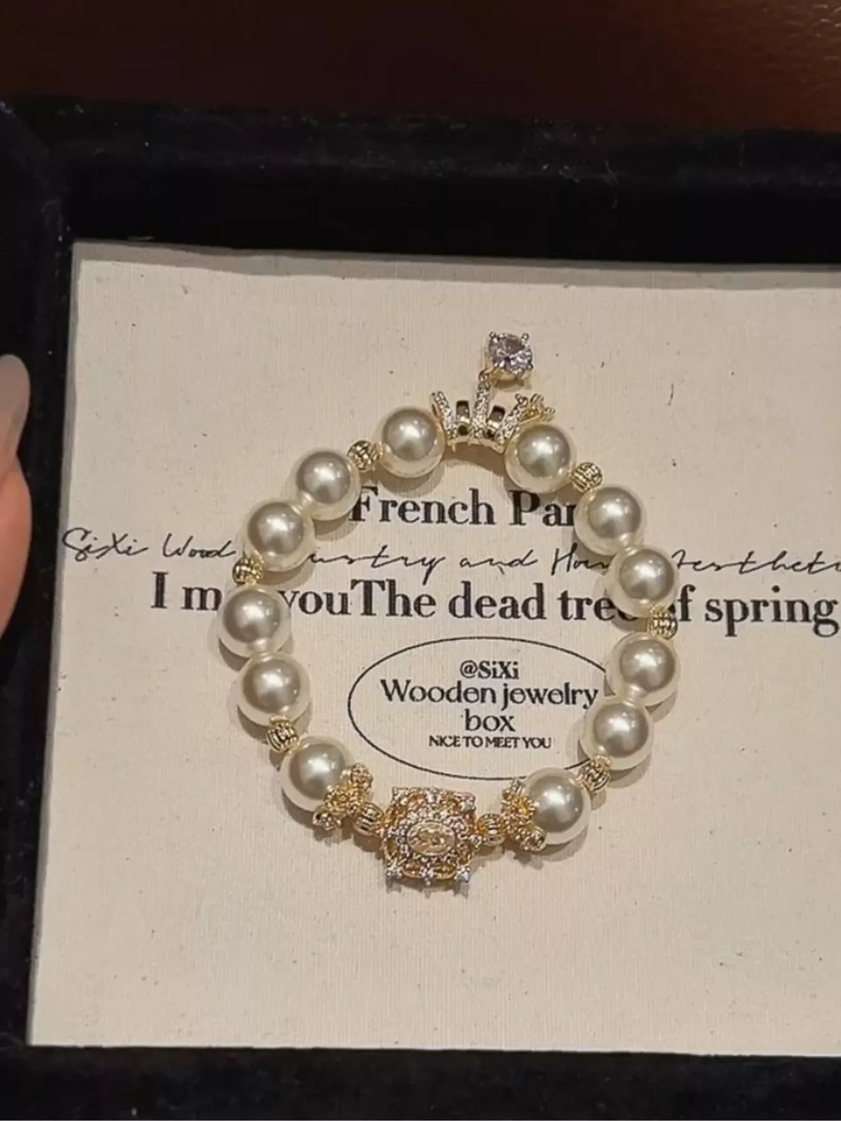 Pearl bracelet with gold accents on a branded jewelry box