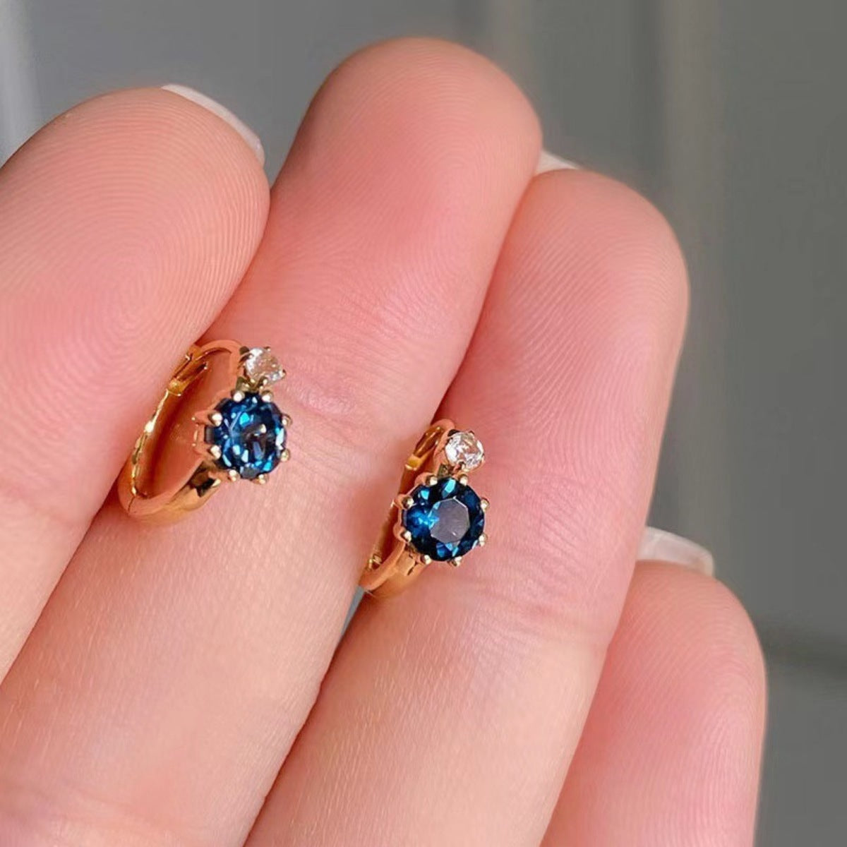 Detail of zircon sparkle and secure clasp on 925 sterling silver hoops
