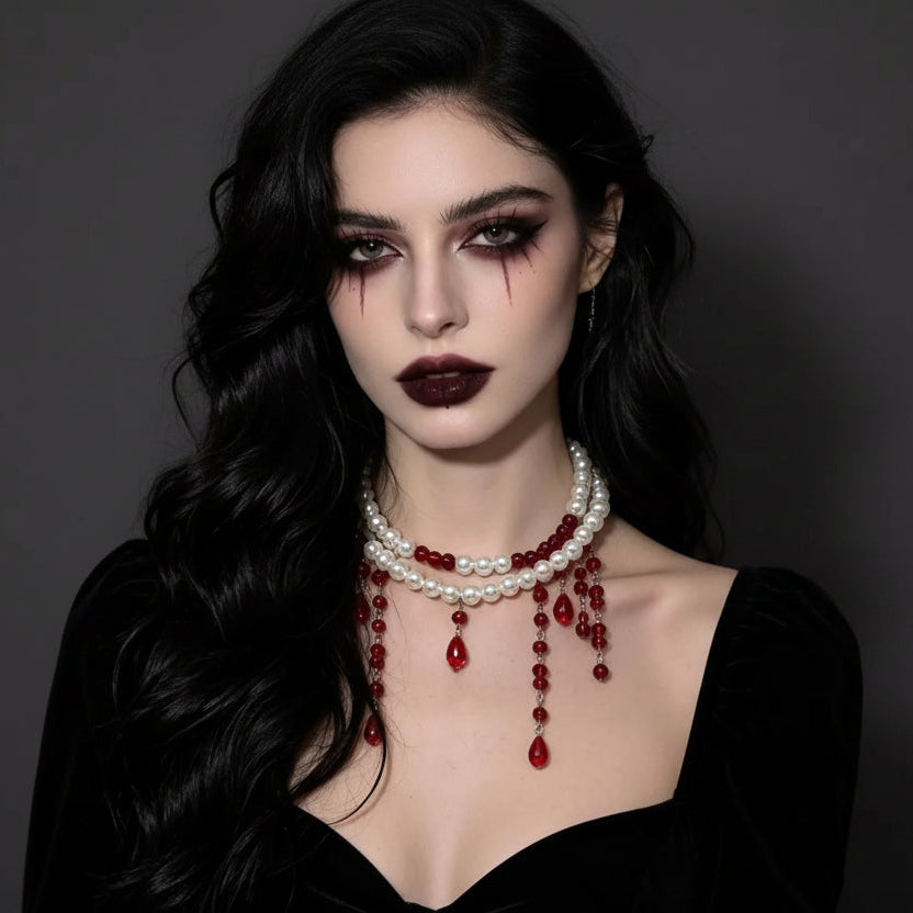 Double-strand pearl choker with red beaded drips worn with a black velvet dress