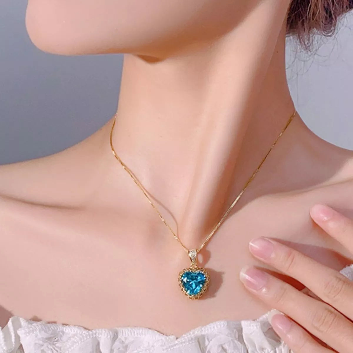 Rebellious Gal heart shaped blue stone necklace aquamarine worn on model collarbone