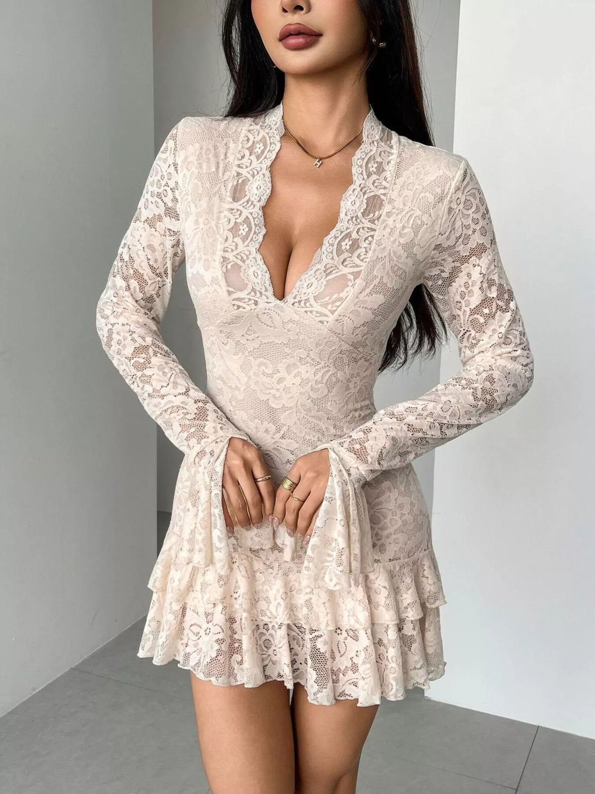 Woman wearing a white lace dress against a neutral background
