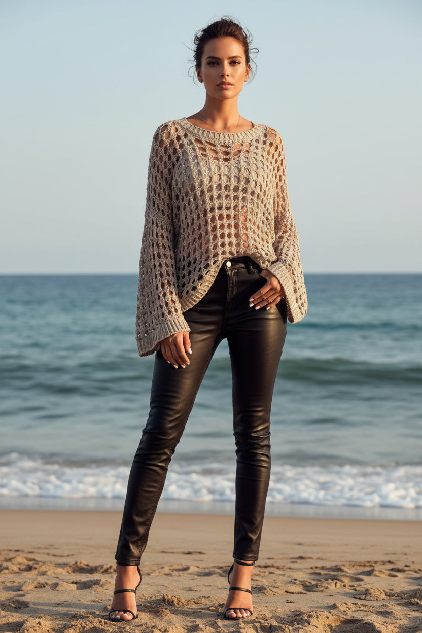 Person wearing a beige crochet top with a blurred ocean background