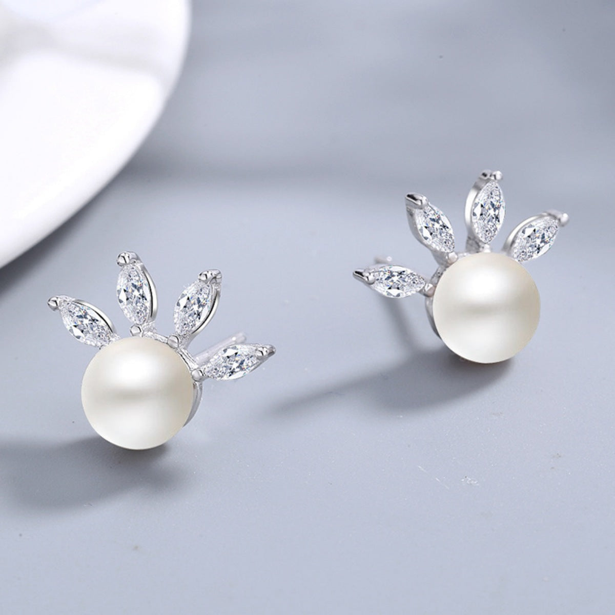 Close-up of dainty freshwater pearl studs showing natural luster and zircon sparkle