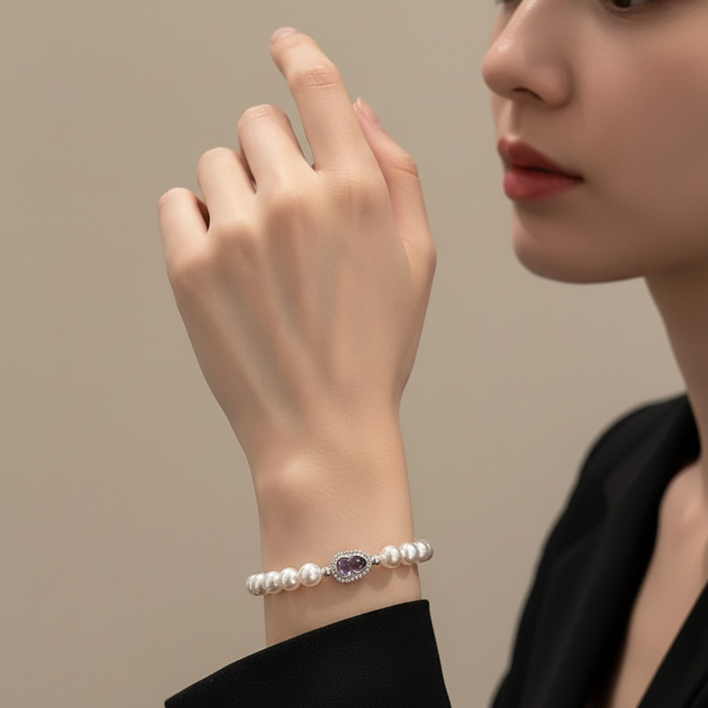 Woman wearing a pearl bracelet with an amethyst stone on a neutral background