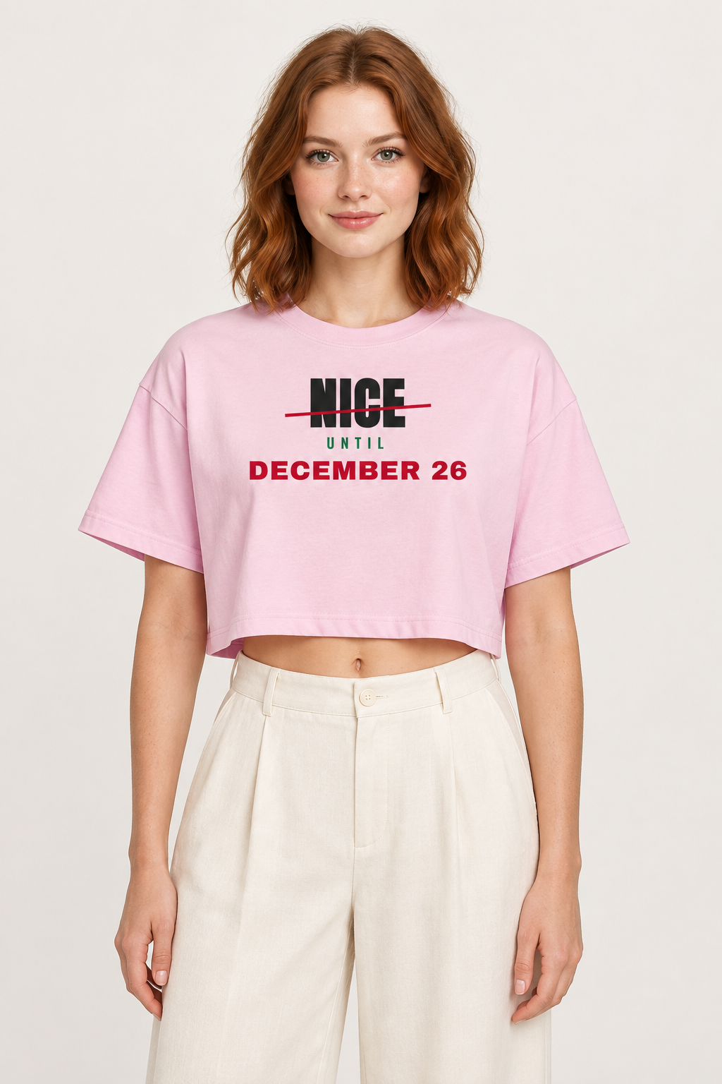 Woman with red hair in the pale rosette Nice Until December 26 crop top, pale backdrop