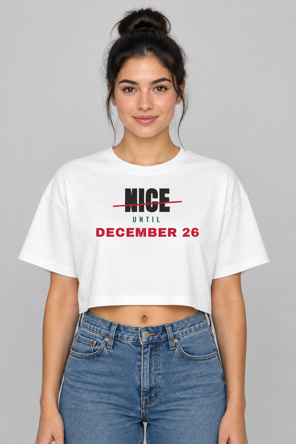 Woman with a dark high bun in the white Nice Until December 26 crop top, studio