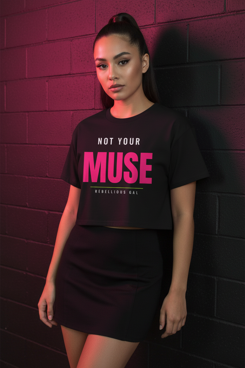 Woman with a high ponytail in the black Not Your Muse boxy crop top, brick wall