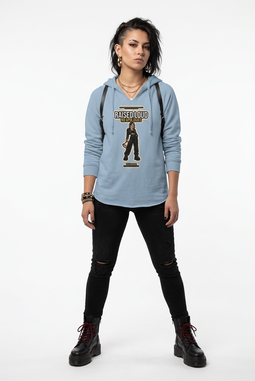 A model stands against a white studio background wearing a light blue graphic hoodie with 'KISSY BUTO' text and a figure print on the front, paired with black ripped skinny pants and black lace-up boots.
