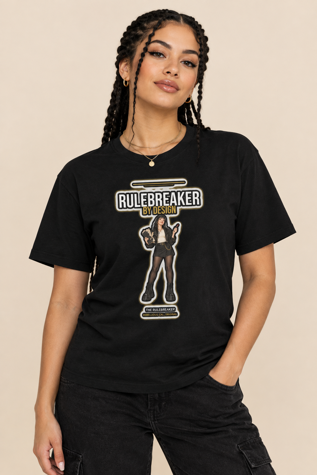Woman with braided hair in the black Rulebreaker tee with gold necklaces, beige backdrop